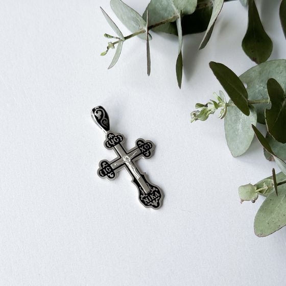A silver cross with a jewel