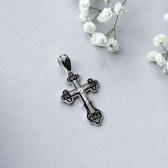 A silver cross with a jewel